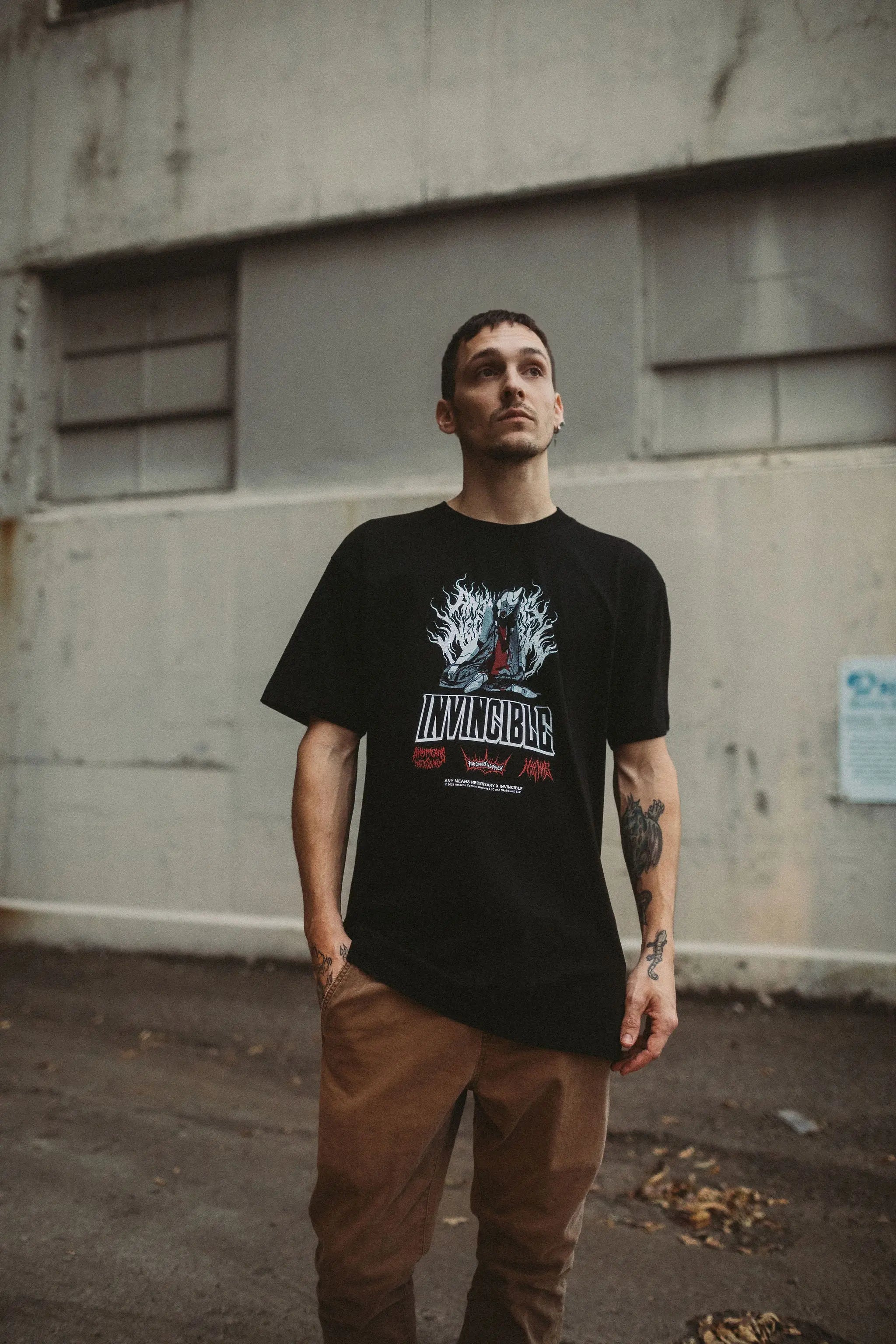 Black Neck Snap T-Shirt by Any Means Necessary Clothing featuring a classic crew neck and snap button details.